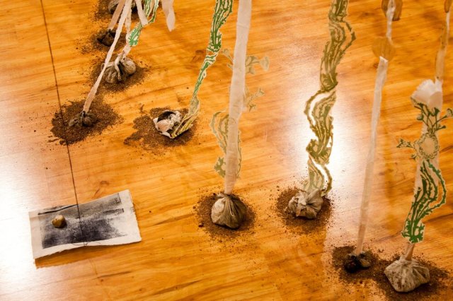 Source: Emily Jalinsky | Inner Calm&nbsp;    Installation with silkscreen on cut paper, embroidery, teabags, and stamps on torn fabric, string and xerox lithography on paper, tarlatan, tea leaves, and rock bundles.    Inside look at materials from Jalinsky: Both the silkscreen and xerox lithography prints were used for other editions and one-of-a-kind pieces. The original books scanned for these prints have been used in my original works for the past five years and continue to be a recurring material in my current work. Teabags and loose tea leaves were from my daily tea rituals. Stamps were hand-carved from erasers I used in college. The fabric was from a small stash of quilting fabric from my late grandmother. The tarlatan bundles were all from previous intaglio print runs and filled with borrowed rocks from my high-school assistant’s personal rock collection.